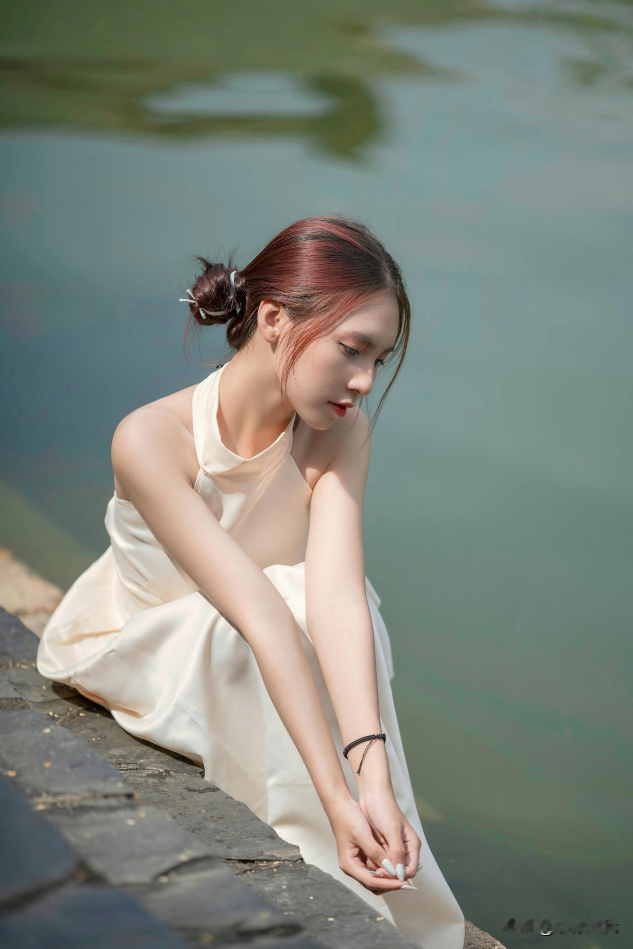 微风掠过湖畔，
缎面裙摆随波纹轻晃。
发梢的红，
在柔光里变淡，
指尖碰一碰水，