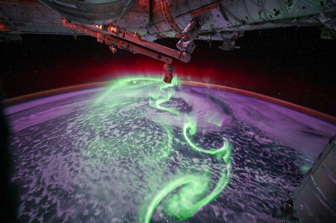 从太空拍摄的极光，在这张图像中，极光似乎勾勒出某些符号。伴随着绿色极光，还能看到