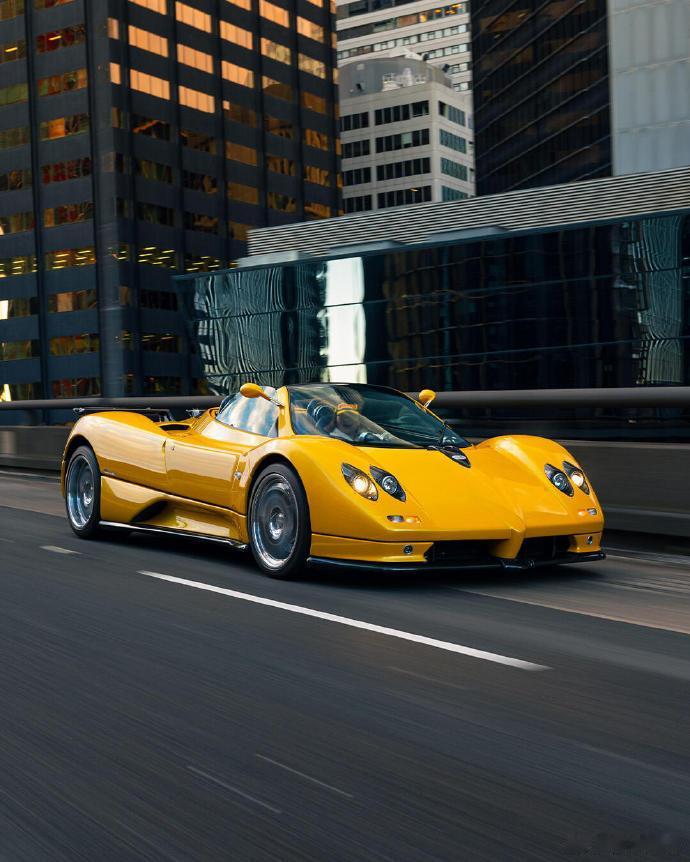 俯拍视角下，亮黄帕加尼 Huayra Roadster 驰骋沥青路面。开放式座舱