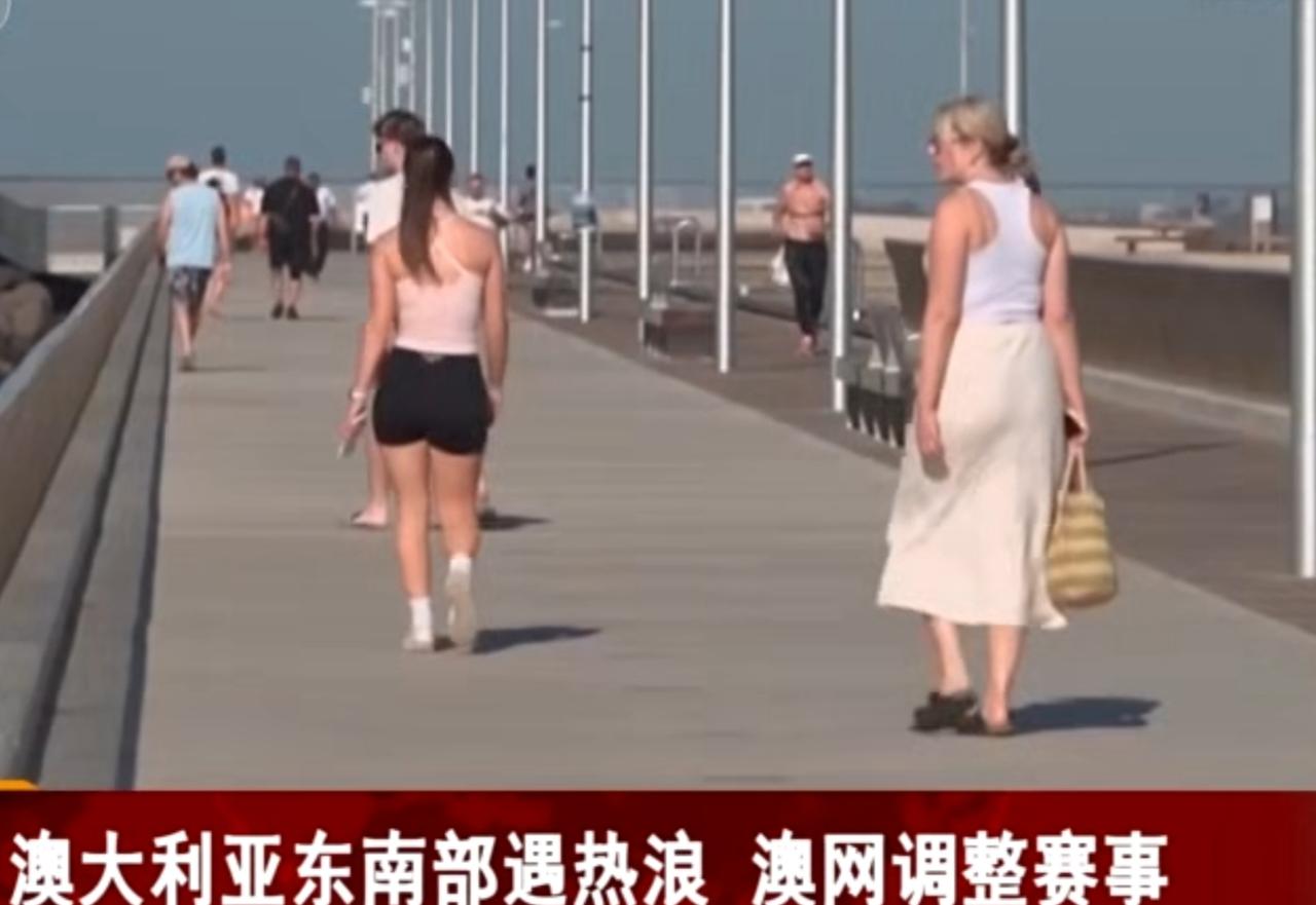 澳大利亚东南部正遭遇极端热浪侵袭，多地气温突破历史极值，海滩上民众泡在海水中降温