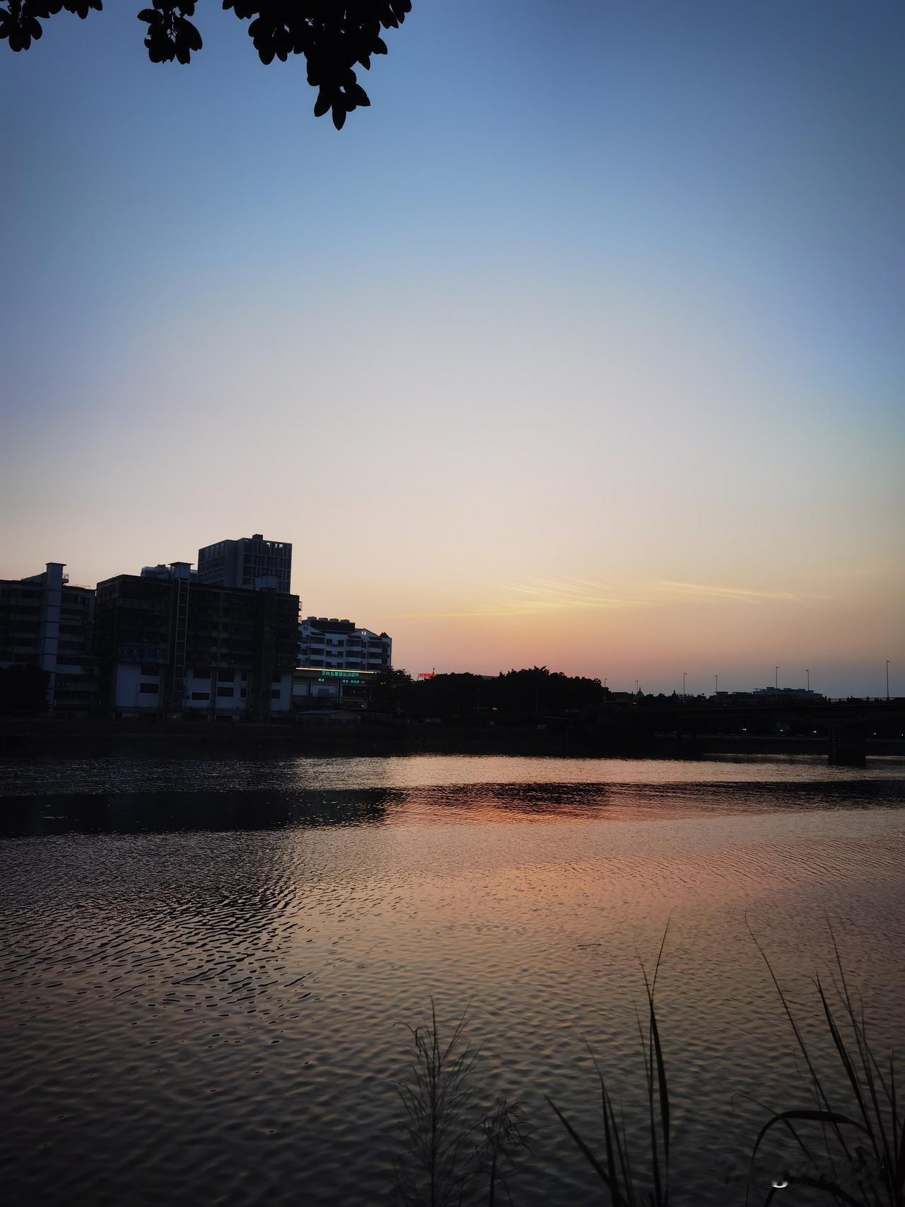 落日黄昏，江畔风景让人忍不住停下脚步，赶紧拿手机拍下如此美的画面，江水微风下泛起