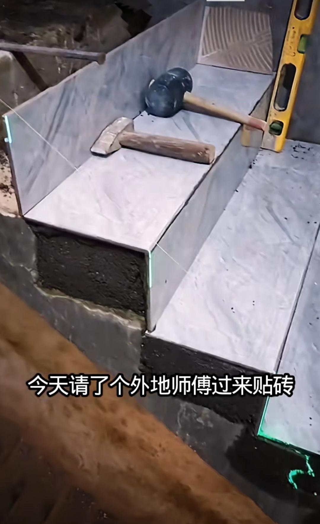 用瓷砖铺贴踏步，打底灰竟与上一步持平了，就这厚度，还是采用层层压的方式贴的。师傅