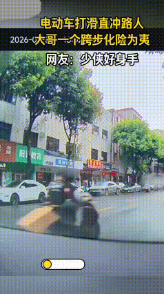 一男子过马路，行至道路中间时，后方一骑电动车的男子突然打滑摔倒。
失控的电动车借