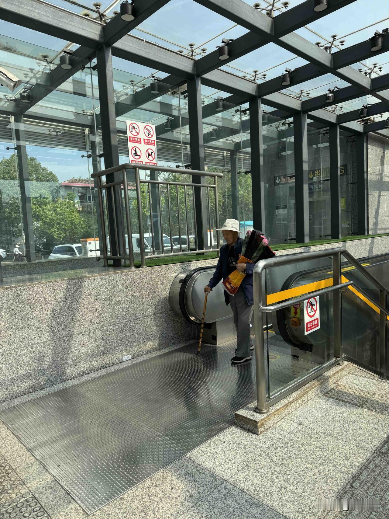 一个拄拐棍的耄耋男老人，怀抱一捧鲜花，步履蹒跚依然心存浪漫，不知道是不是送给心爱