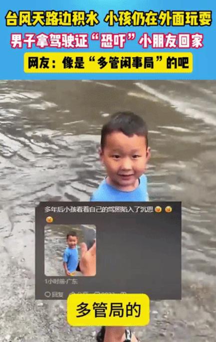 ”可是让他装了把大的！“广东一小男孩正在踩水玩，路面积水看起来还有些深，旁边一男