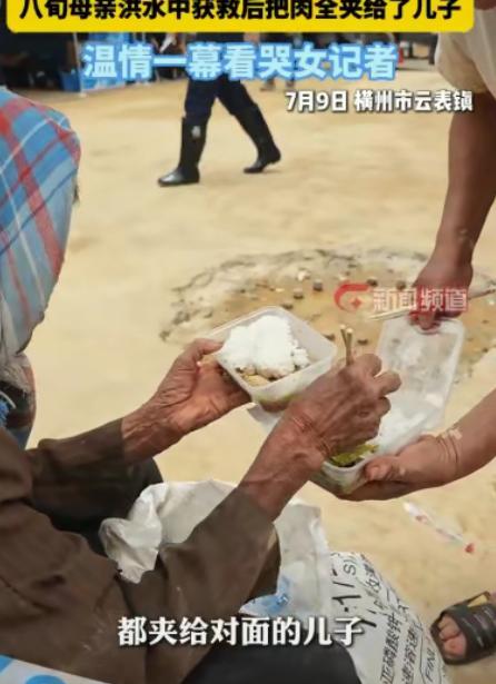 广西横州洪水里，一对母子被消防员及时救出。刚分到盒饭，80岁母亲第一件事不是自己