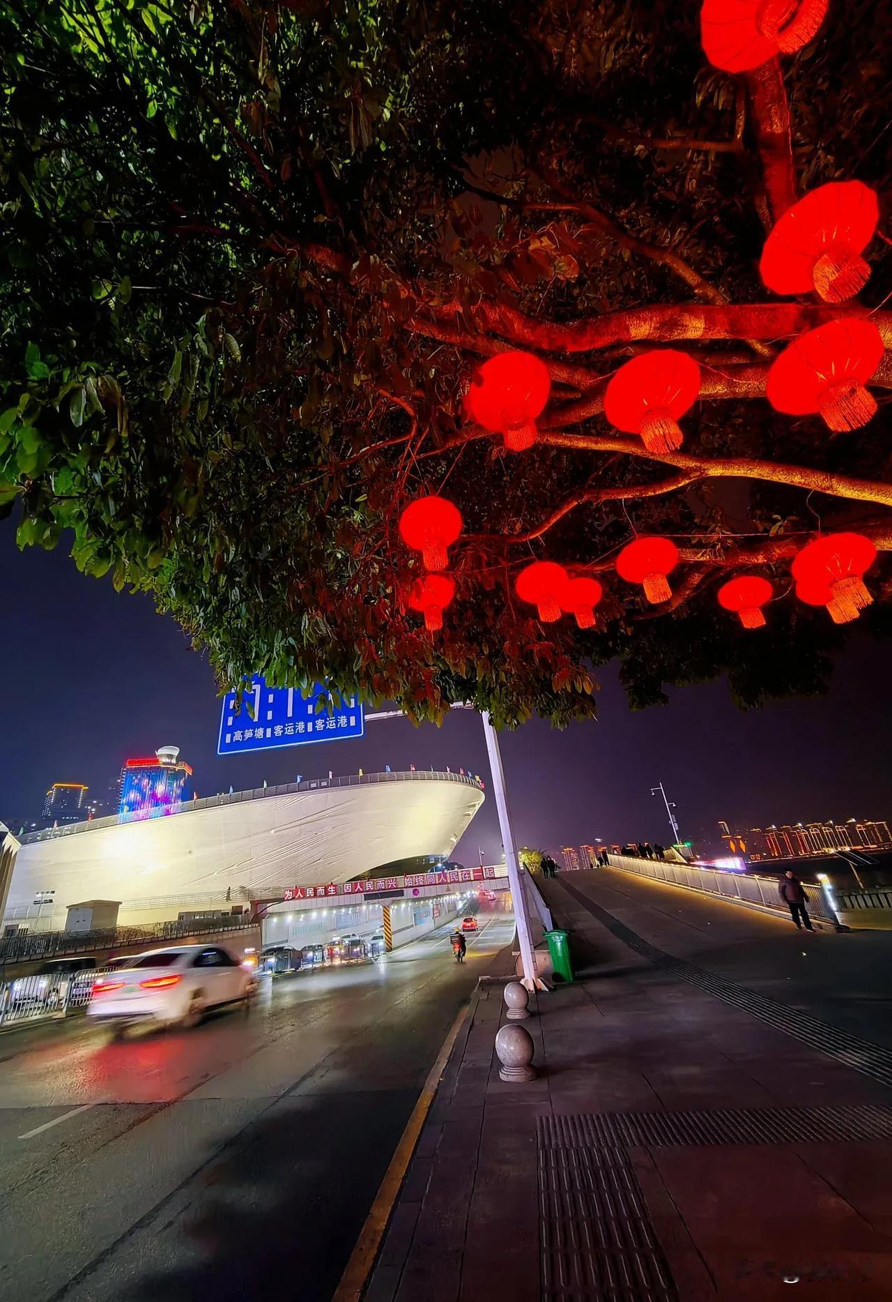 周末的夜晚，万州区北滨路一段兩边人行道，树上掛满大灯笼，红彤彤的，喜庆的浓浓年味