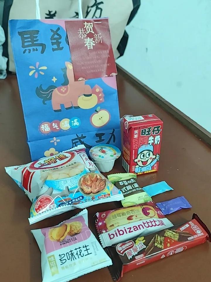 今日初八开工，社区送了小袋礼物有9种不相同口味的食物，有糖果，旺仔牛奶，鲜虾片，
