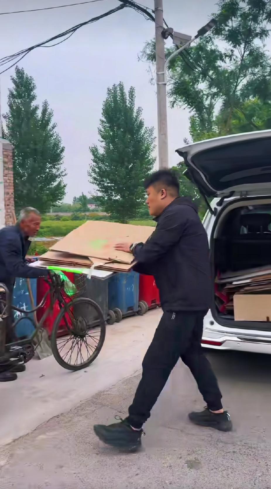 路边的垃圾桶旁，一位拾荒老人正在翻捡废品，一辆小车突然停了下来，接下来看到的一幕