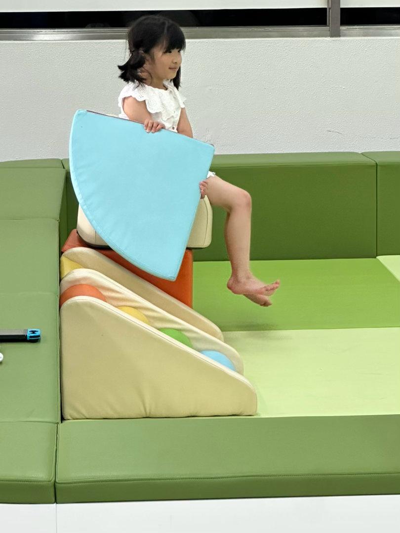 机场里有个很小的playground。有一个白人小女孩和海星在里面玩。小女孩一看