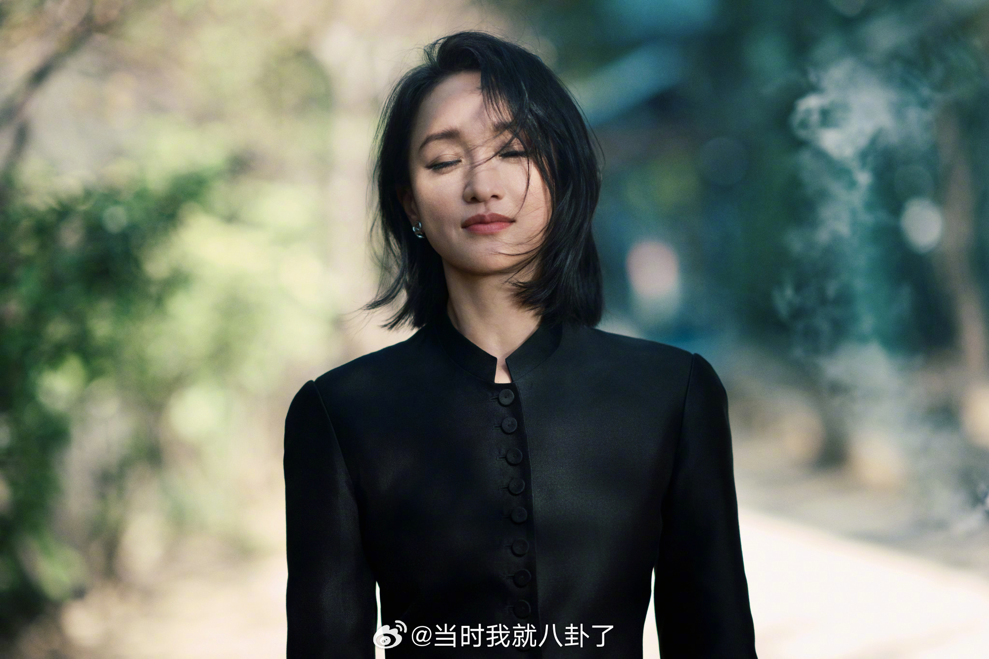 一袭黑衣翩然于林间小径，风拂发丝，尽显优雅风姿，当年那个活泼灵动的精灵如今多了一