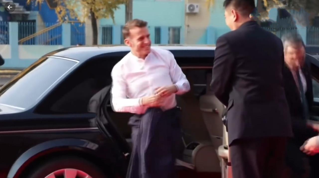 12月5日马克龙抵达四川大学，他从车上下来穿着一件白衬衫，手里拿着一件西服外套，