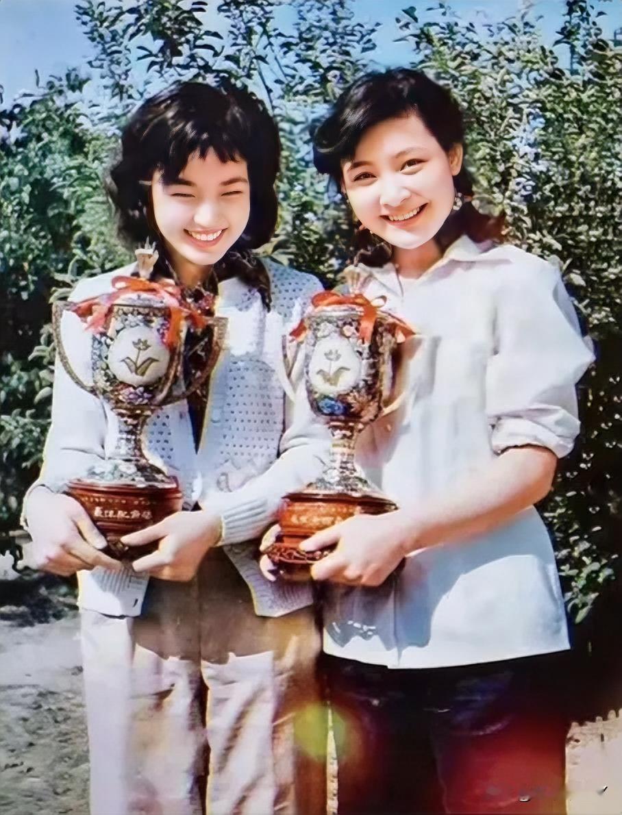 这张照片定格了1980年，刘晓庆与陈冲荣获百花奖时的美好瞬间。照片中两人抱着奖杯