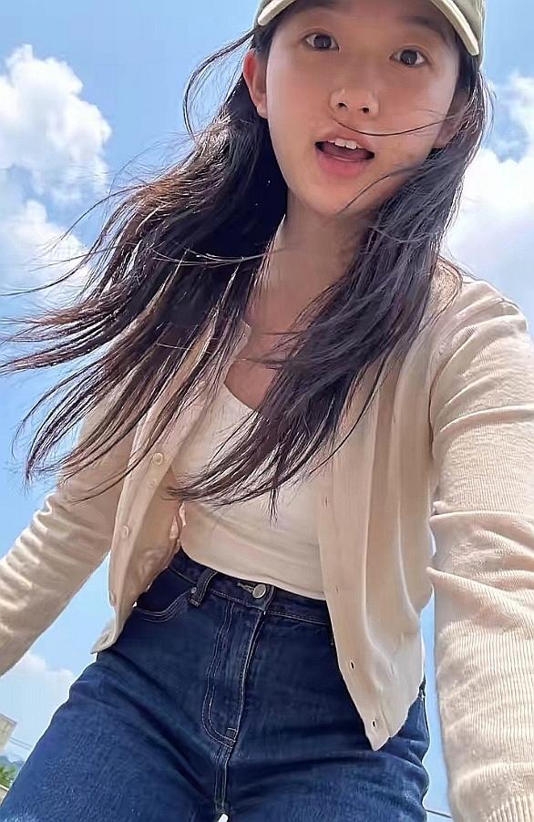 小女孩调整手机方位，准备自拍。