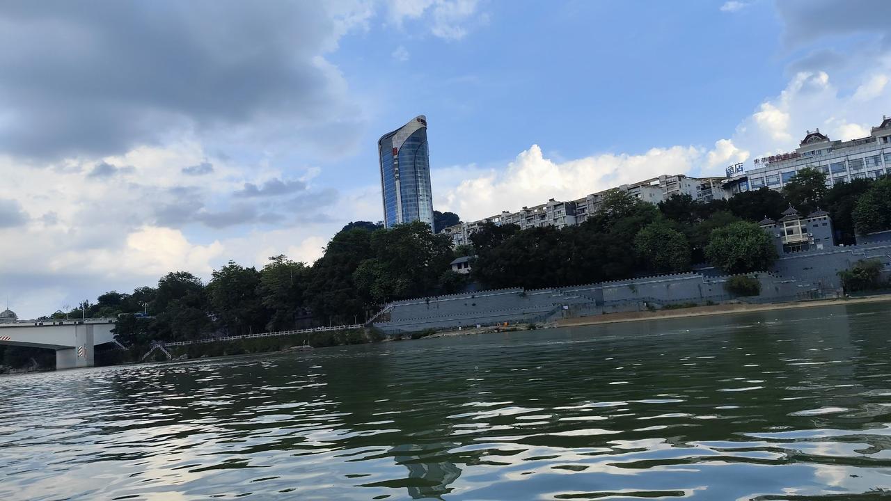 柳江的水是绿的，绿得深，绿得静，像把整座城的夏意都沉在了里面。风掠过去，水面就起