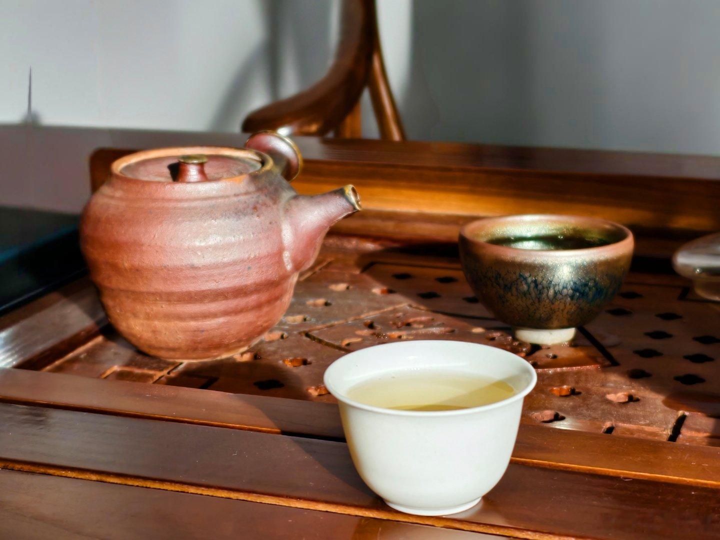 雨住了，黄昏的日光，突然透过窗户落在了桌子上，落在茶杯上，杯子里的茶水，也发出脉
