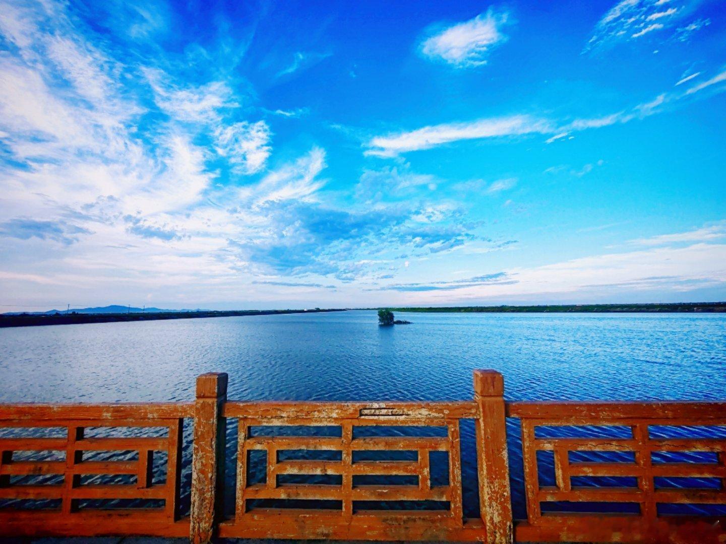 随手拍 天气炎热，蓝天白云，河水清悠悠的。河边不少人纳凉散步，吹着河面来的风，总