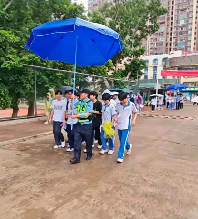 6月9日清晨，高考第三天，湛江徐闻县突降小雨。考场外，民警撑着大大的遮阳伞，为赶