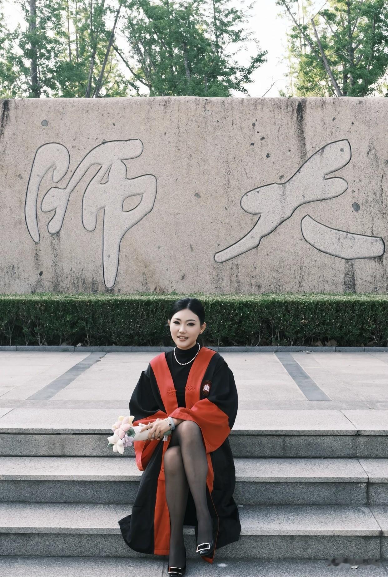 记录我的2026这位姐姐穿着毕业礼服，拿着花拍照。