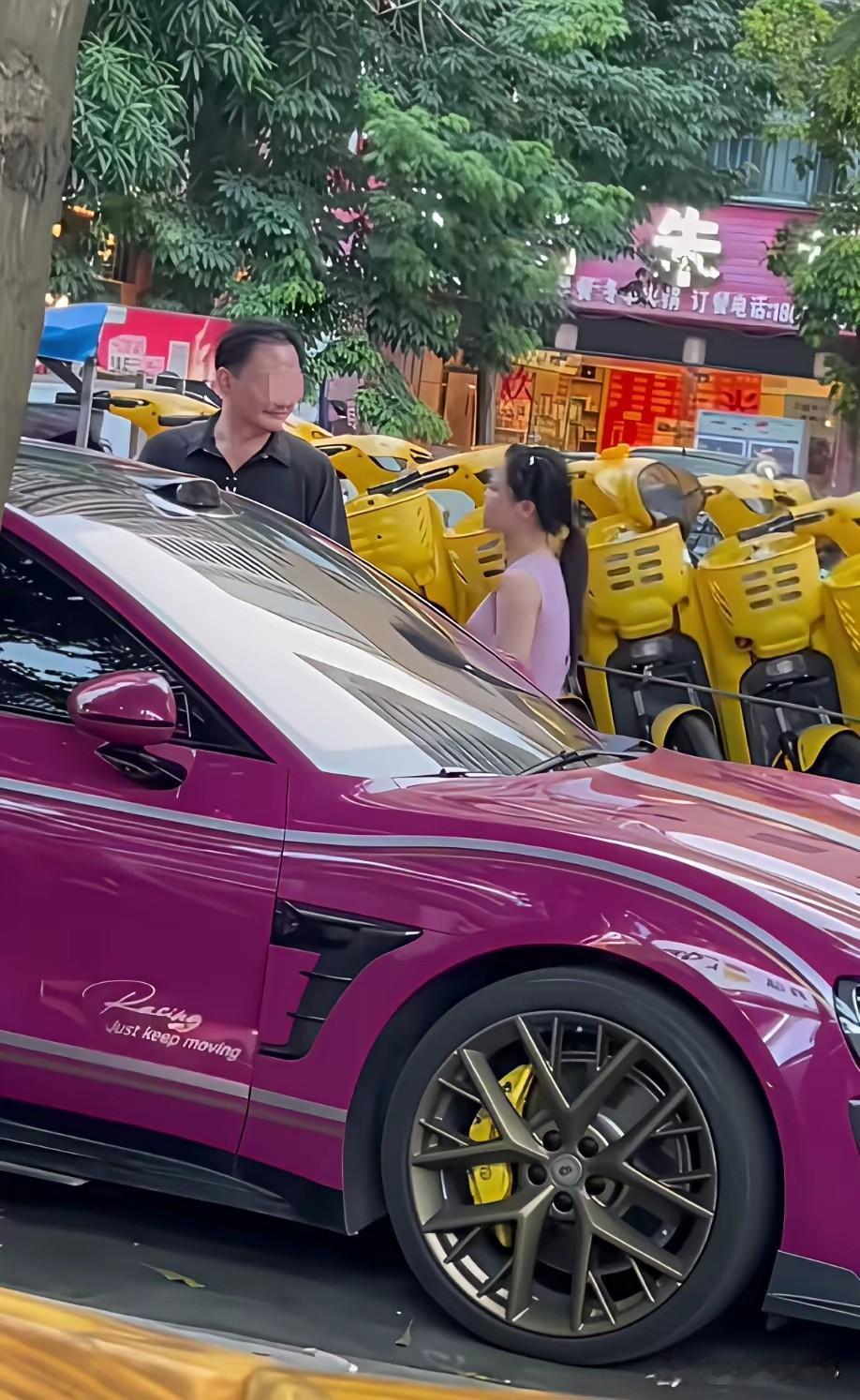 南宁街头一女子穿着粉色裙子，气冲冲地和路人说着什么，旁边一男子开着小米车，一脸不