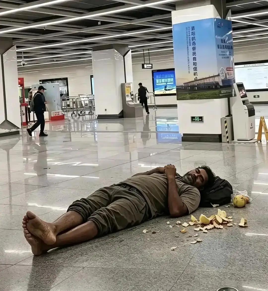 在某机场大厅，睡觉的印度人。旁边还摆了一堆垃圾。一看就是印度人自己制造的垃圾。也