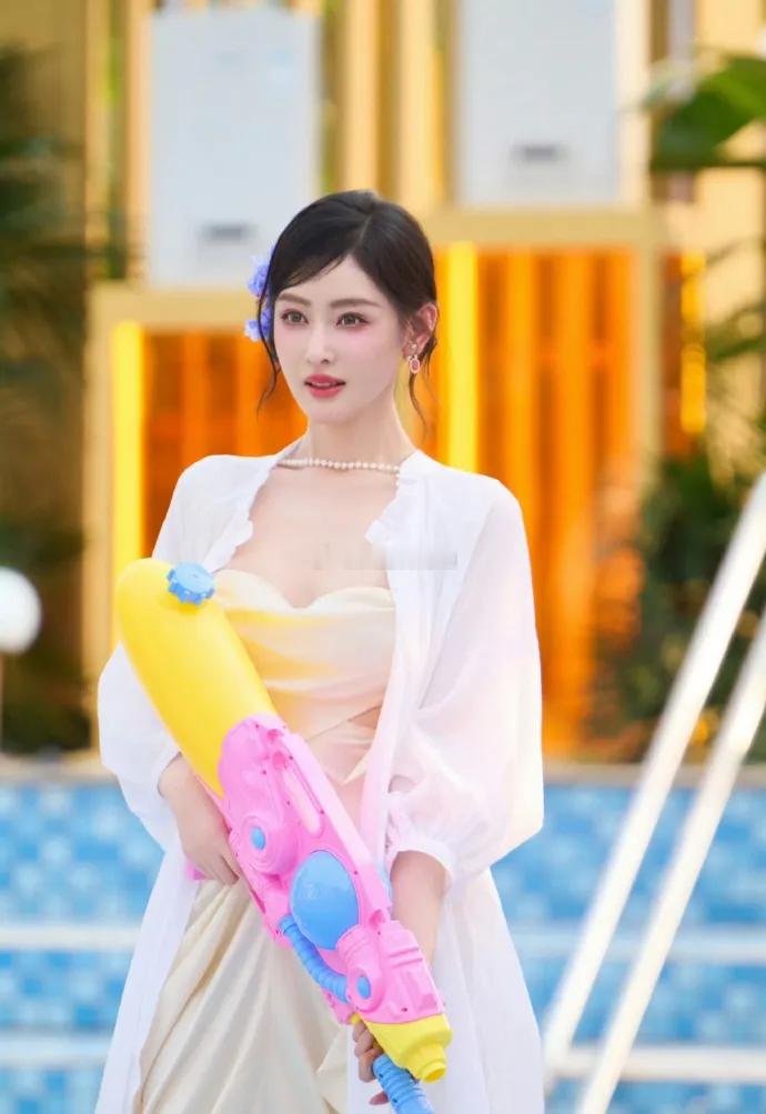 张天爱现身西双版纳像个迷人的春日仙子，一件白色的裙子，裙子上面有很多迷人的褶皱，