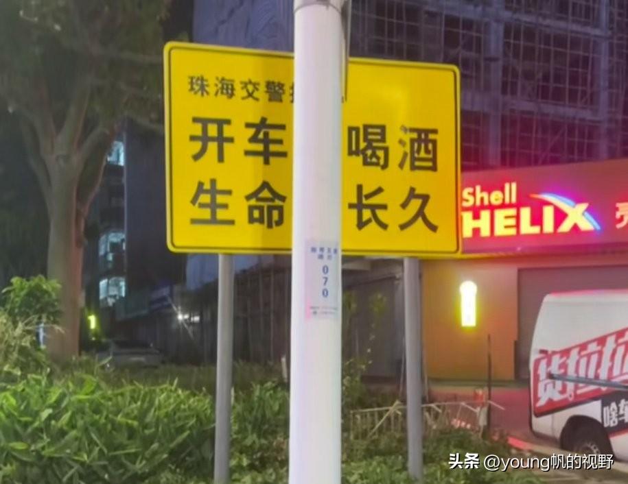 珠海的一块交通安全警示牌，树立的内容正好被一根灯柱给遮挡了部分。警示牌原本的内容