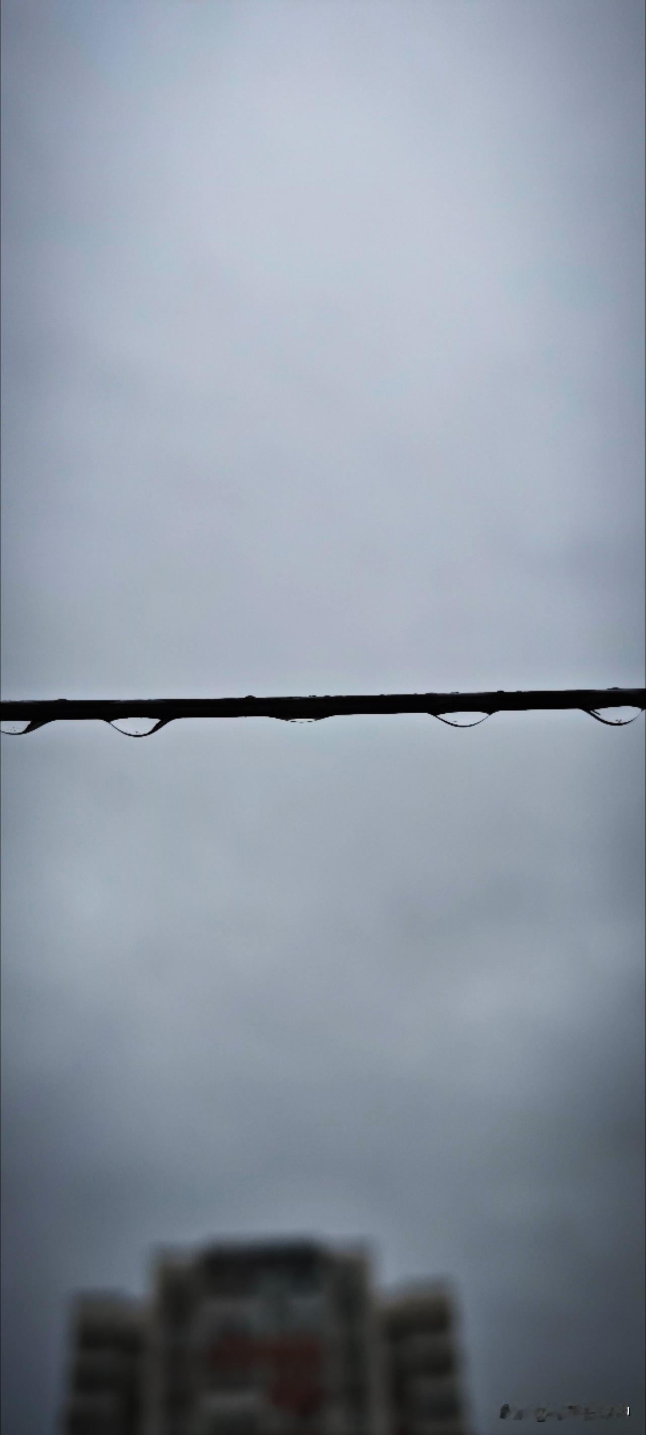 雨水落在晾衣绳上，悄悄地汇成雨珠，遇着风儿吹，似是承不住倒映的世界，瞬时跌落碎去