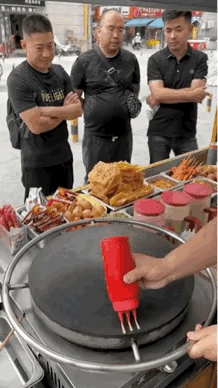 这样的煎饼果子，我都不舍得吃了。
 
大街上，三名男子正站在一个摊位前等待着煎饼