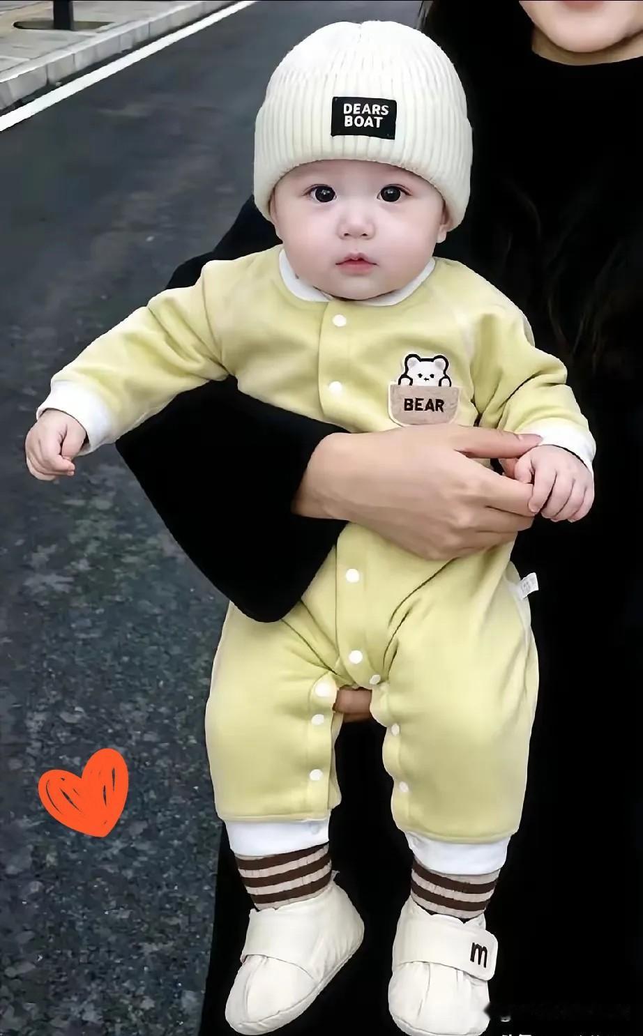 可怜的孩子呀！皮肤嫩嫩的，长得白白胖胖，一双眼睛乌黑油亮，穿着小黄衣戴着奶白小帽