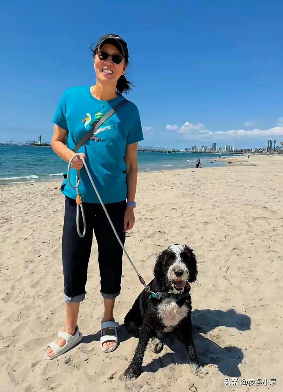 65岁郎平和女儿在美国海边度假，她牵着一条大狗，看起来好悠闲。现在郎平定居美国，