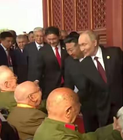 在天安门城楼，普京总统、金正恩委员长等外国嘉宾同中国抗日战争的老八路握手致意…