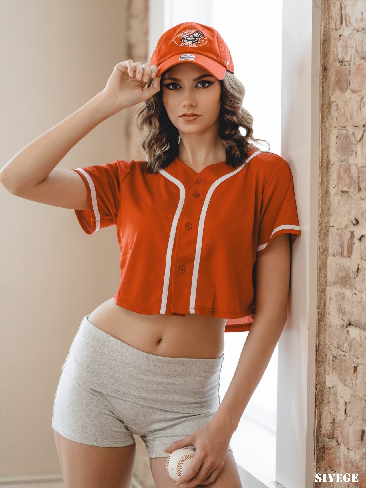 埃莉丝·霍弗（Elyse Hofer）穿着一件红色短款球衣、灰色短裤和条纹及膝袜