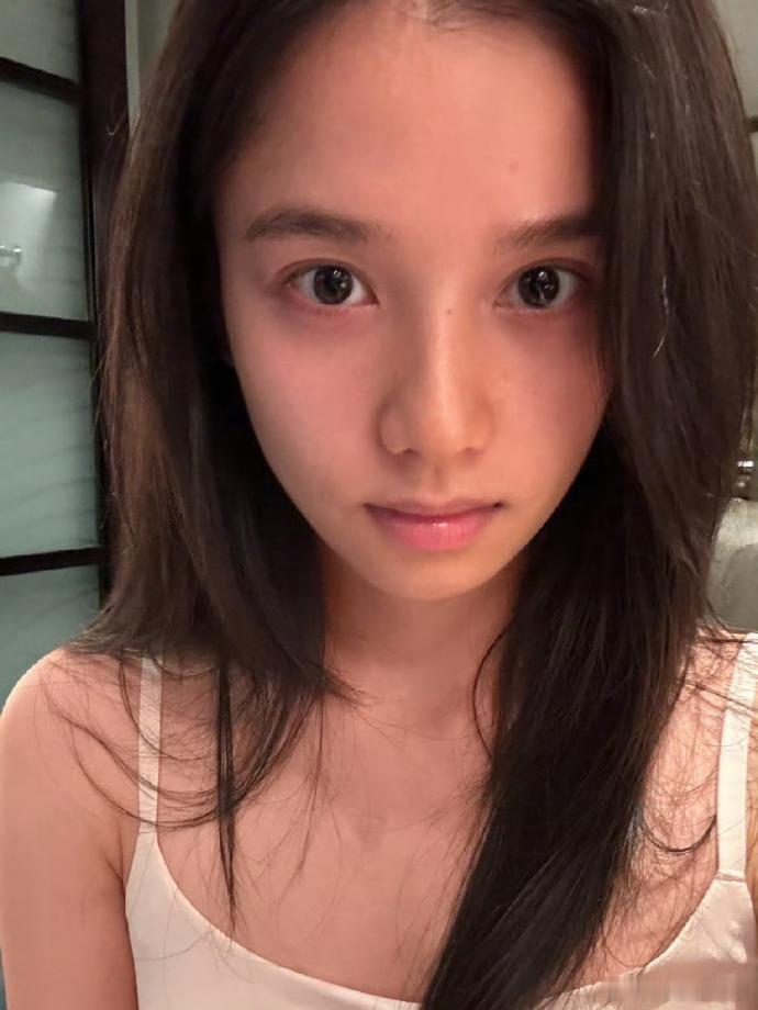 张婧仪素颜女大妆前镜头记录张婧仪真实素颜，化身氛围感女大，没有过多修饰，眉眼清透