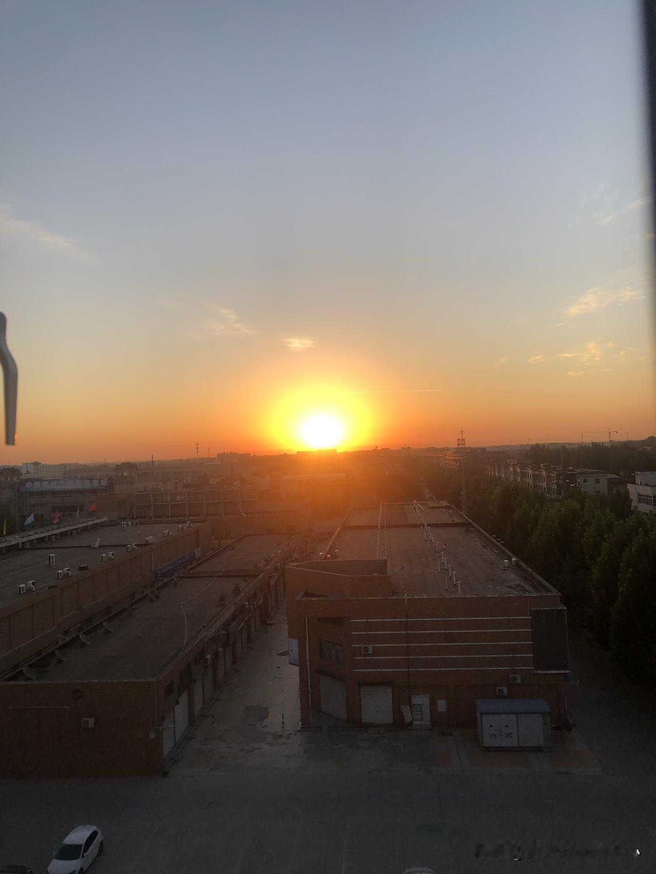傍晚的太阳悬在城郊尽头，像一枚烧得透亮的金橘，把半边天染成暖橙与浅蓝的交界。光芒