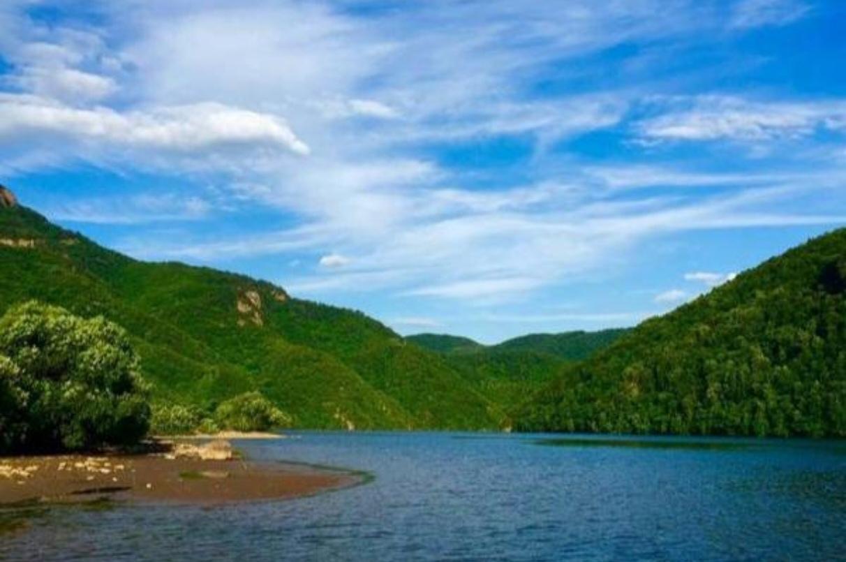 。左岸青山含黛，村舍静穆；右岸城廓错落，烟火悠然 。
断桥残躯静立，弹痕藏岁月峥