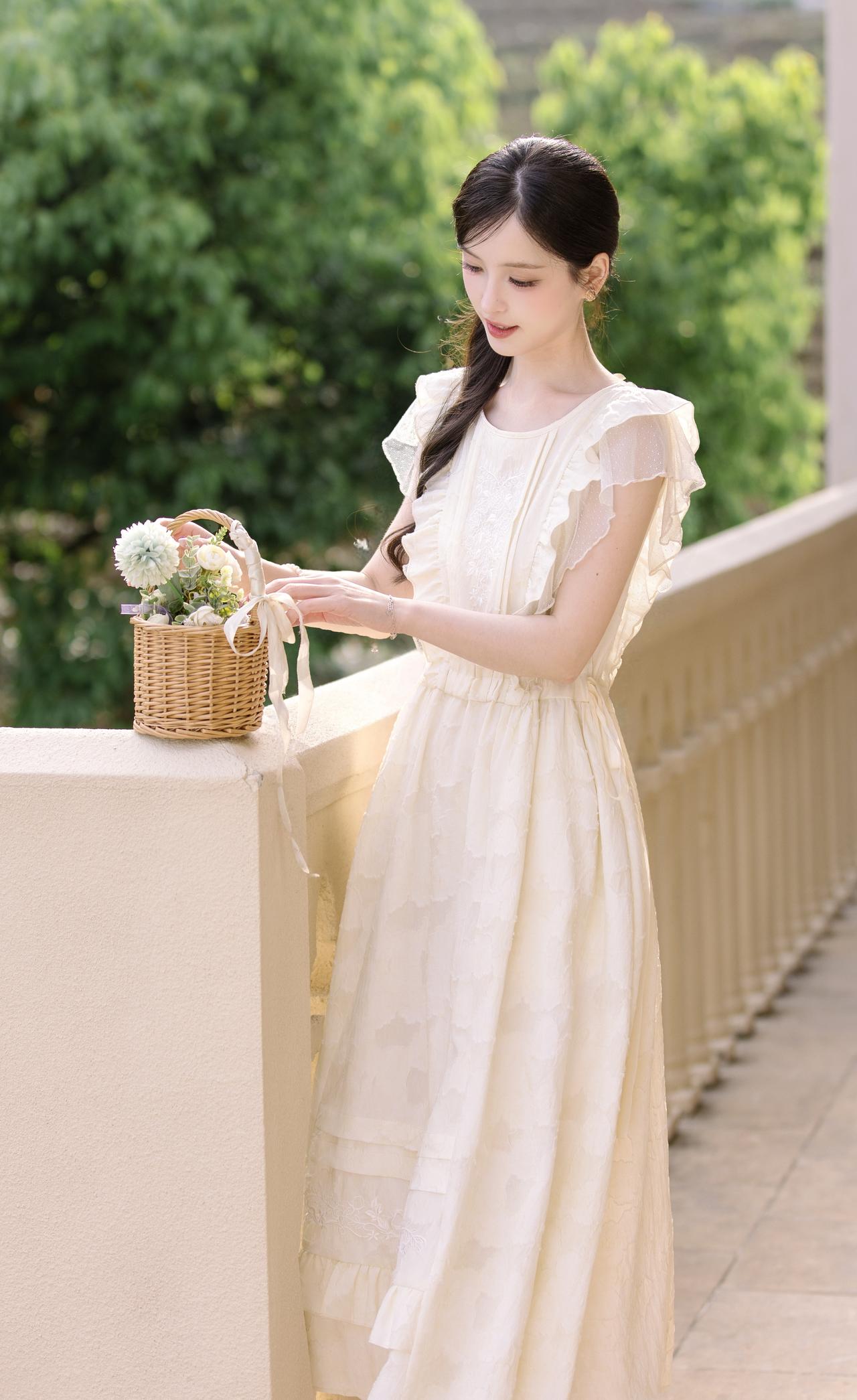 阳光漫过温柔的檐角，奶油白的裙裾缀着细碎蕾丝与荷叶边，轻晃的花篮盛满了春日浪漫。