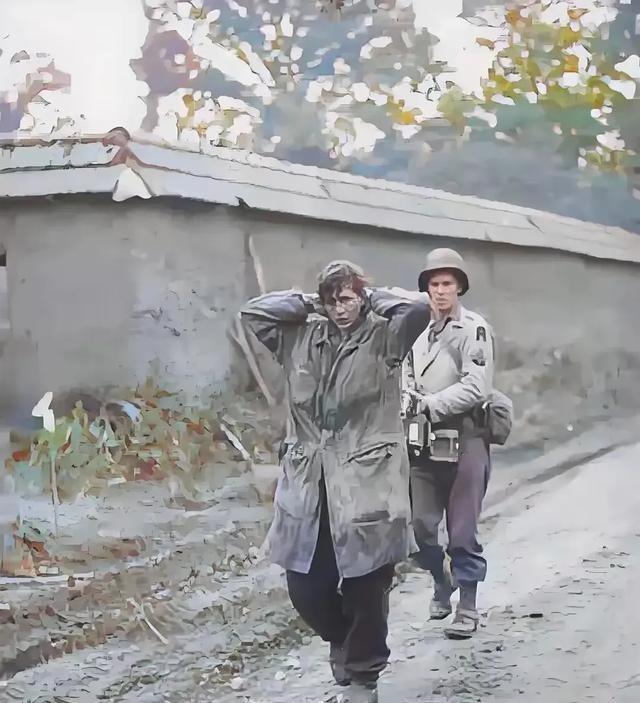 1945年， 美军 士兵正在押解 德军 女战俘。这名女兵身高足有1米75，留着利