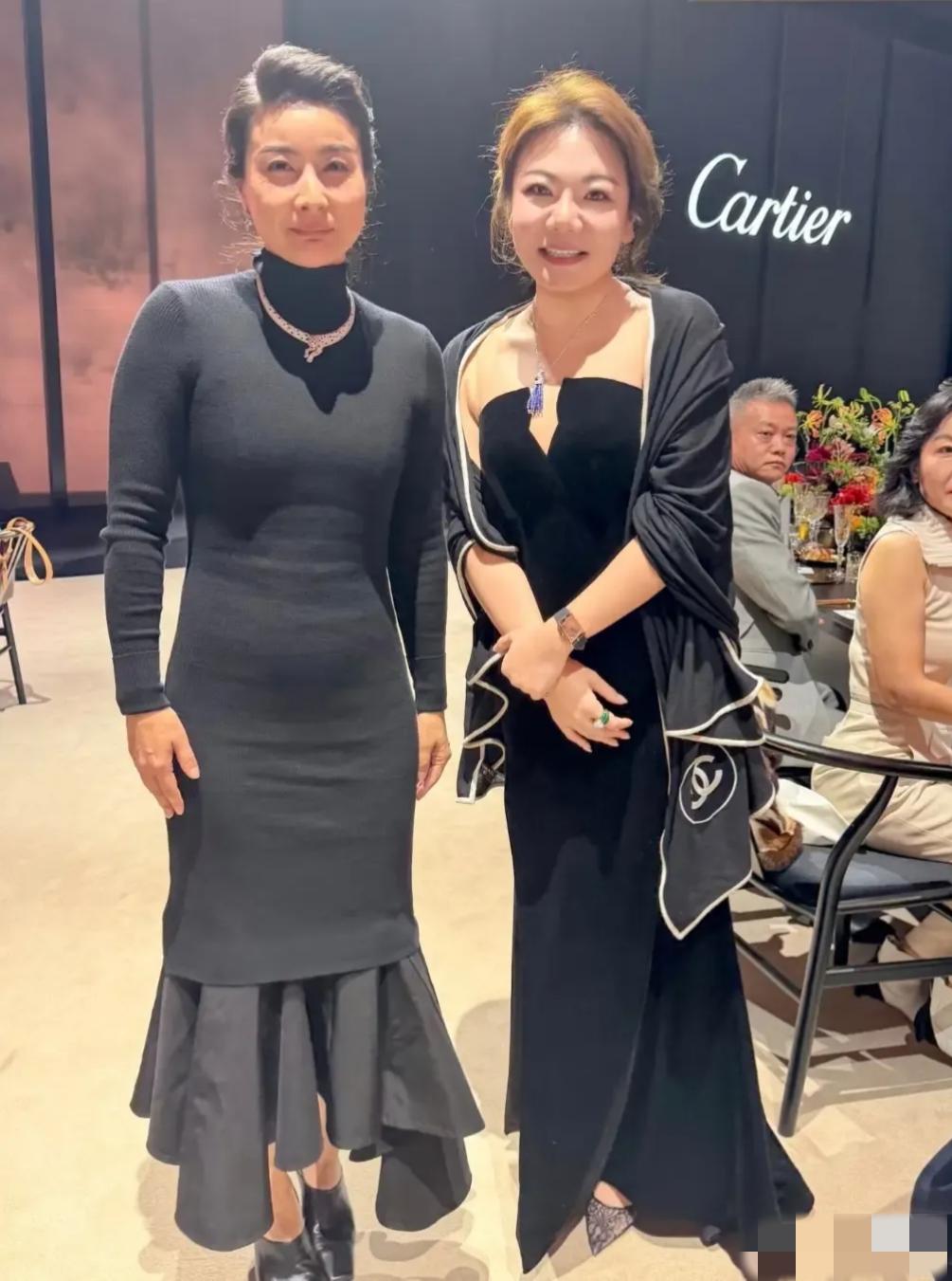 镜头中身着黑色高领紧身礼服的郭晶晶略显发福，腹部隆起，衣袖上皱褶堆积，手臂上青筋