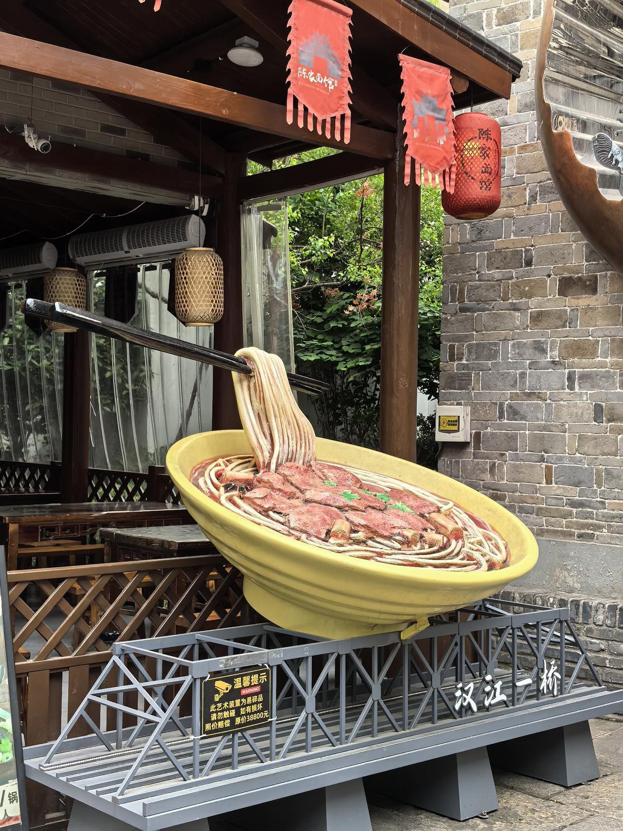 一碗大面落汉江，
千丝万缕煮襄阳，
桥边古巷陈家味，
烟火人间岁月长。