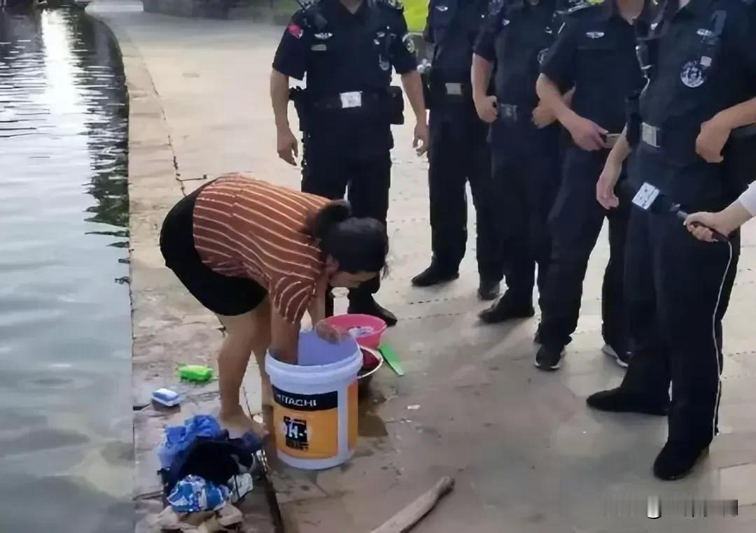 一名村姑正在河边洗衣服，几个穿制服的人突然围到她身边，拉着一副黑脸严励地质问她：