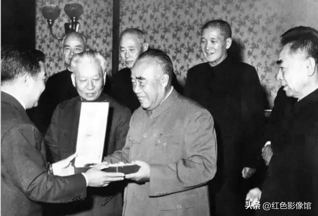1955年怀仁堂授勋大典，朱德元帅上前领取勋章，刘少奇、周恩来立于一旁见证。这场