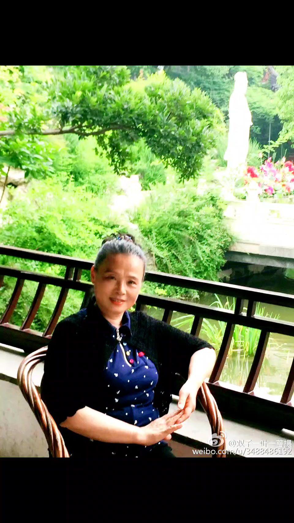 在这绿意盎然的园林间，寻一方静谧角落。她静静坐着，似与周遭的花草、流水一同，将时