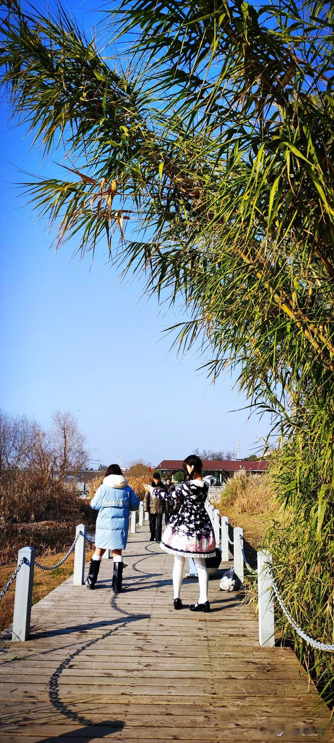 晒图笔记大赛打扮的美美哒，女生对着镜头摆着造型，掌镜的女生看着画面指挥着...先