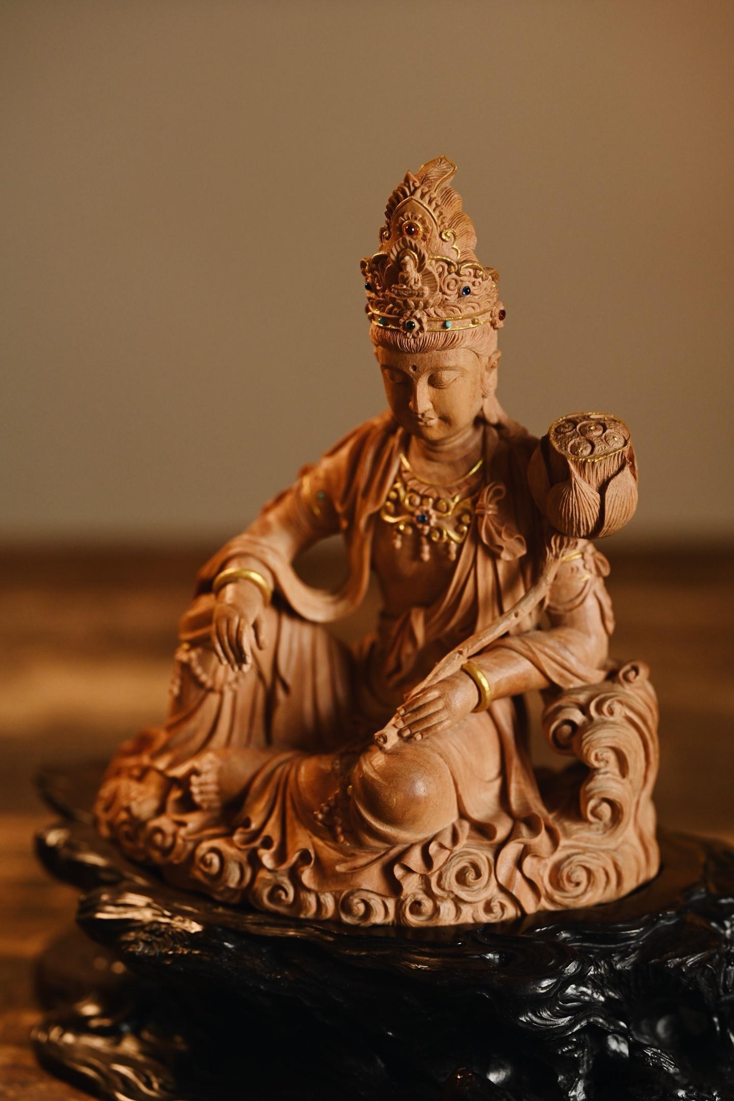 老山檀“自在观音”木料质地细腻温润，雕刻观音呈闲适自在坐式，面容恬静慈和，双目微
