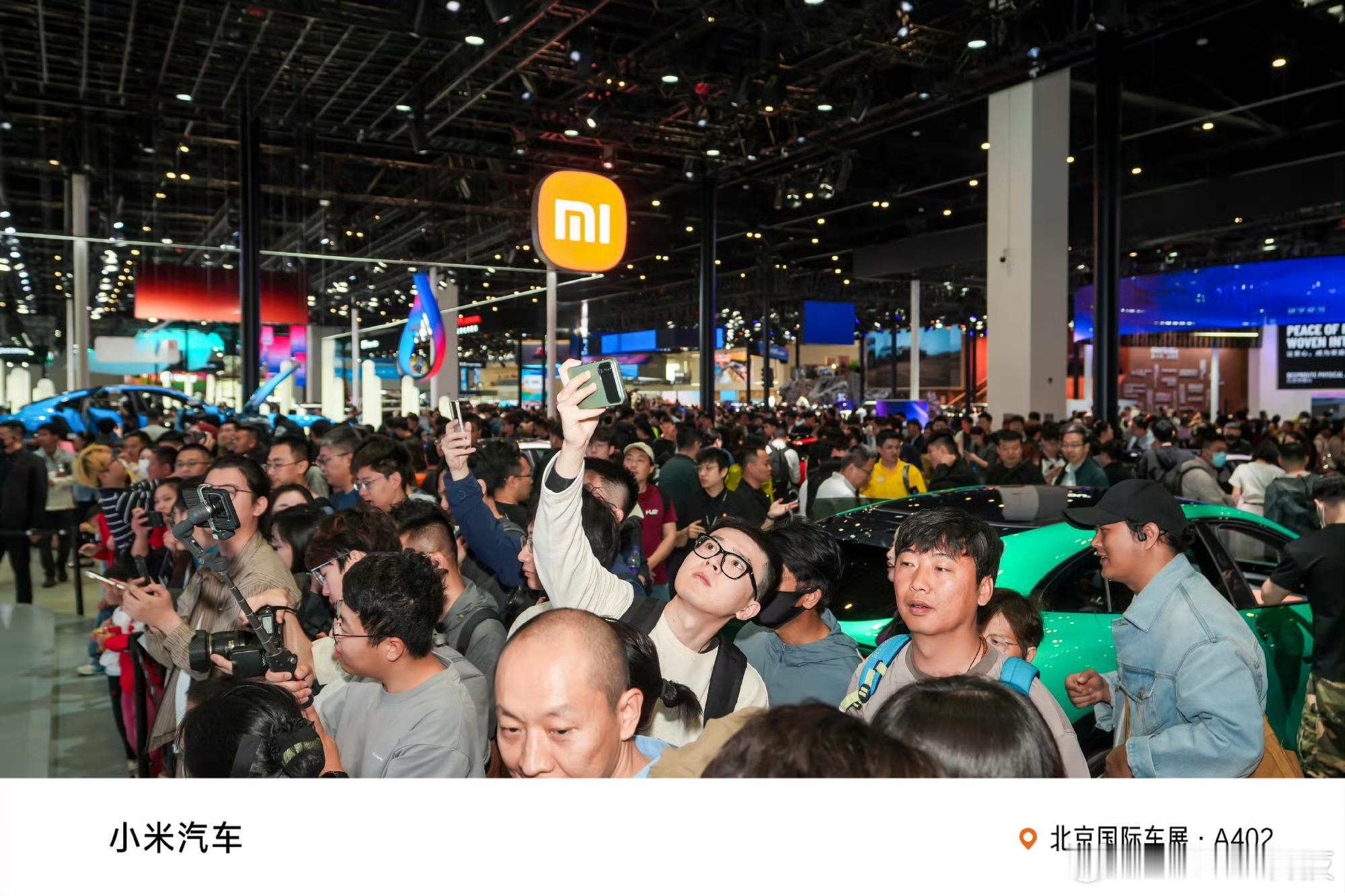 老外踮脚看中国智造北京车展这两天，小米展台成了“景点”。人挤人不说，最显眼的是那
