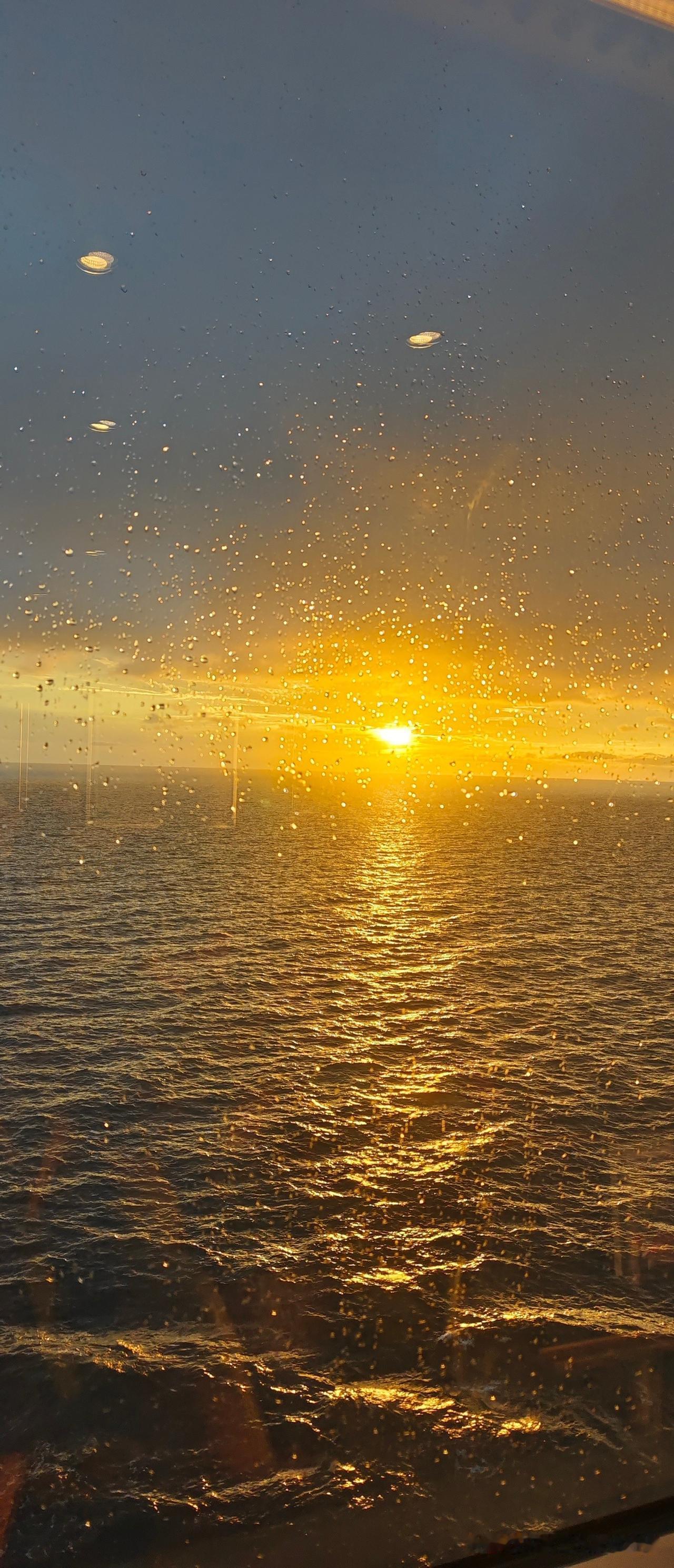 海畔落日，藏着世间最温柔的浪漫
 
隔着沾了雨珠的玻璃望出去，海面被落日揉成了一