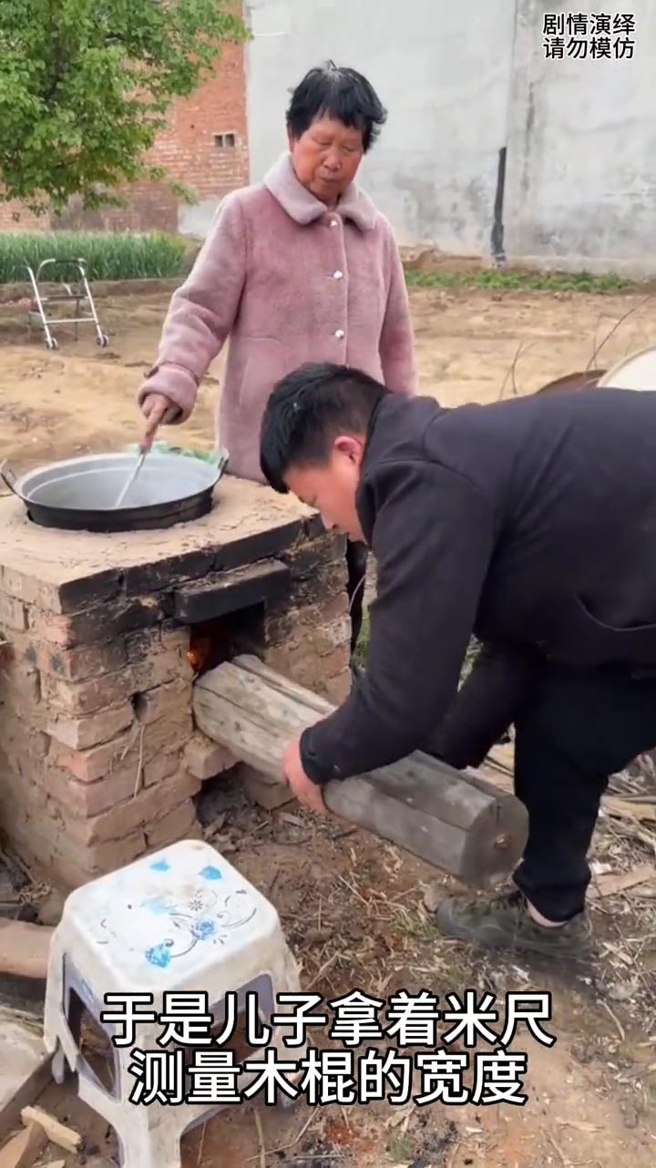 母子做饭时儿子拿的木棍放不进灶火里，下一秒母亲的做法太有才了。
母子两个正在烧地