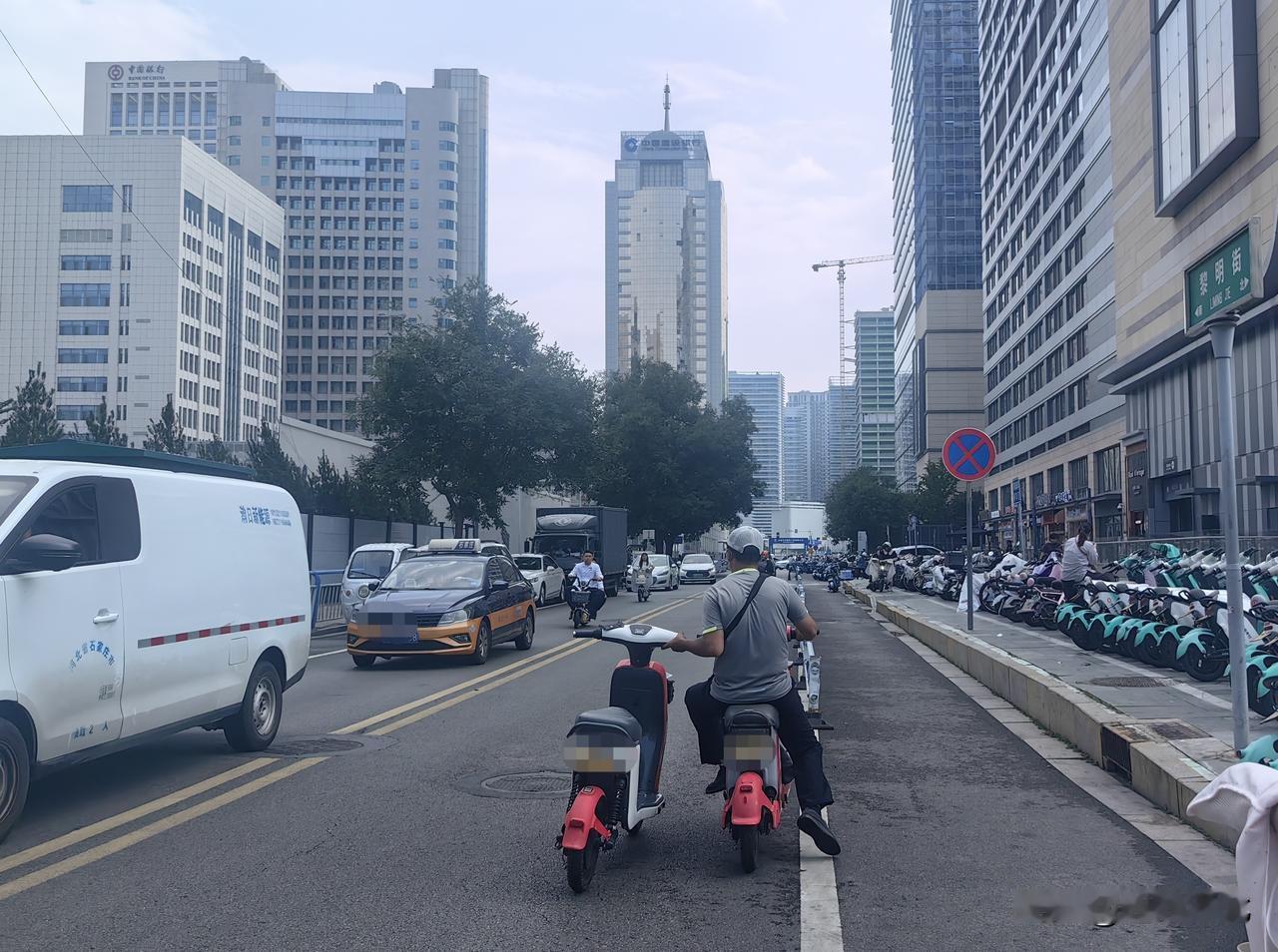 被拖拽的共享电动车没有独立骑手掌控方向，完全依靠运维人员单手牵引，行驶过程中车辆