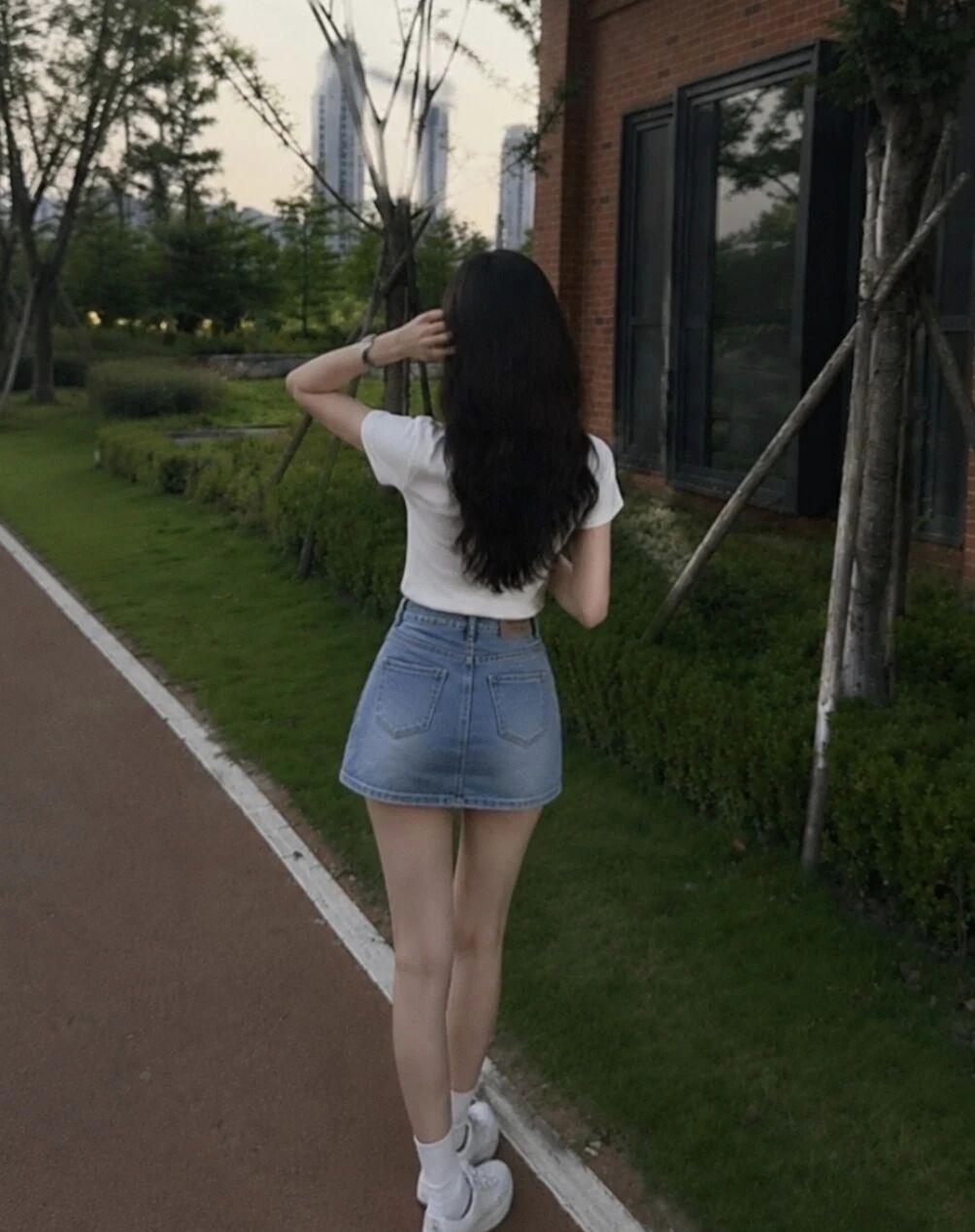 夏日漫步，牛仔短裙与绿意相伴，轻松自在。